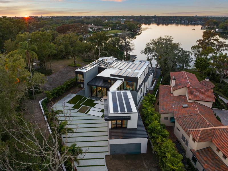 Aerial view of the lakefront show home at sunset — The New American Home 2026, Orlando FL