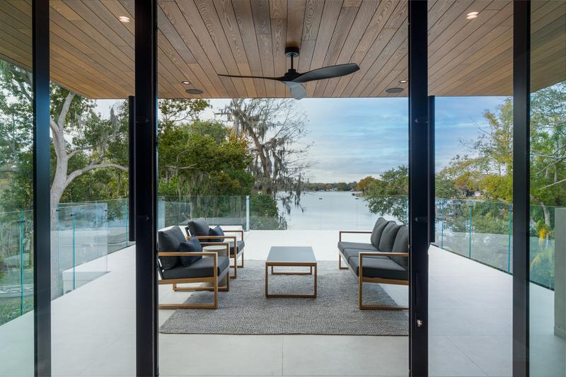 Covered lakeside terrace with lounge seating — The New American Home 2026, Orlando FL