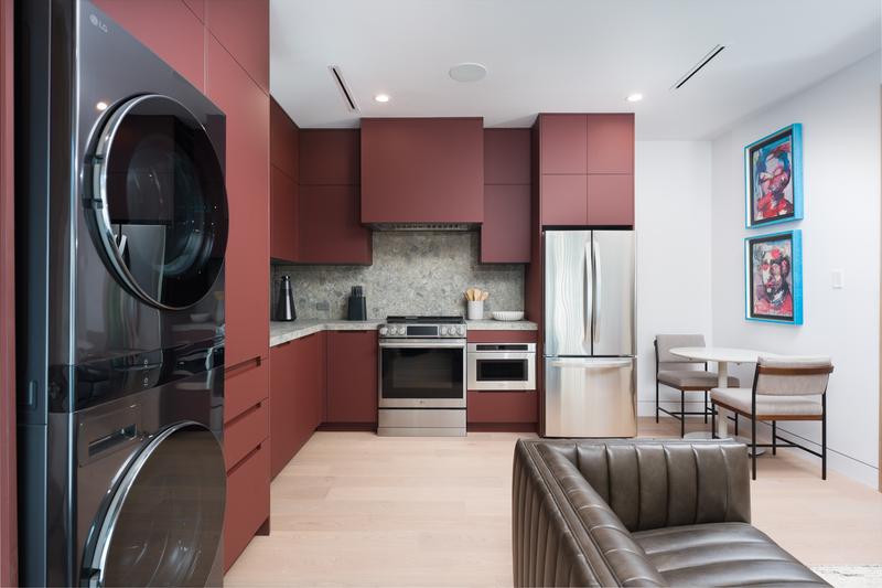 Laundry room with stacked washers and oxblood cabinetry — The New American Home 2026, Orlando FL