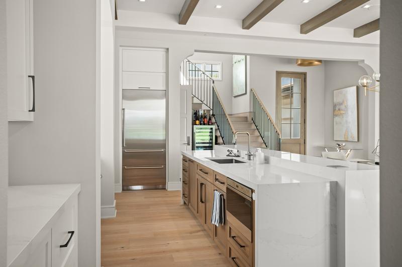 Kitchen with paneled appliances and staircase beyond — Ritz-Carlton Residences at Grande Lakes, Orlando FL