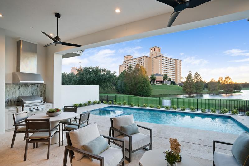 Covered lanai with summer kitchen, pool, and resort view — Ritz-Carlton Residences at Grande Lakes, Orlando FL