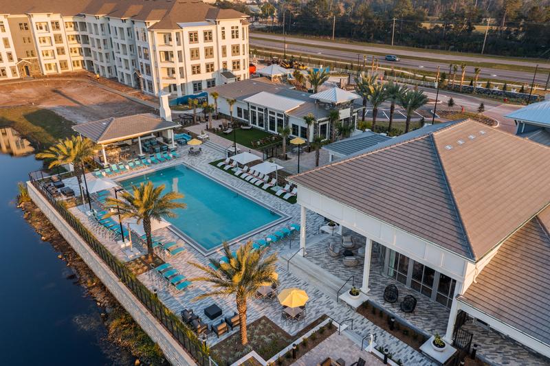 Aerial view of the pool amenity and clubhouse at sunrise — Sanctuary at Daytona apartments, Daytona Beach FL