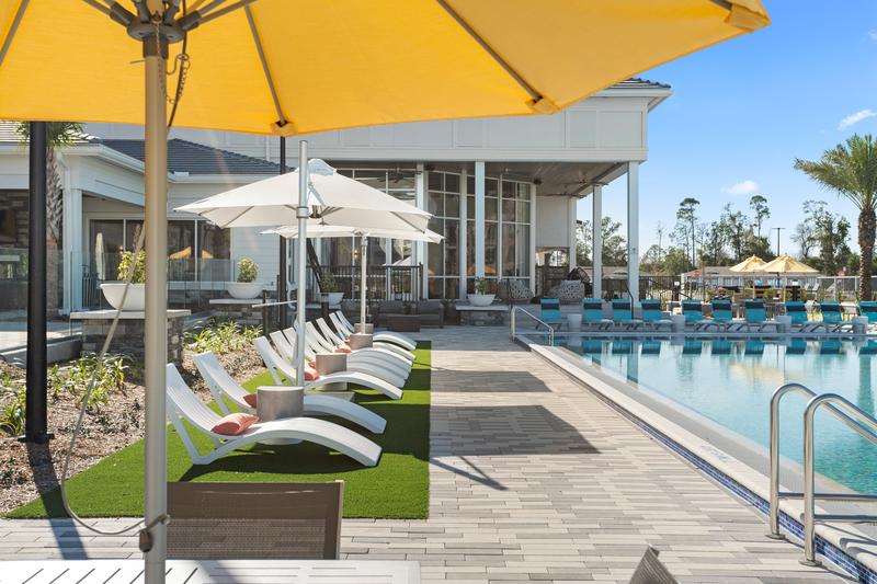 Pool deck with yellow umbrellas — Sanctuary at Daytona apartments, Daytona Beach FL